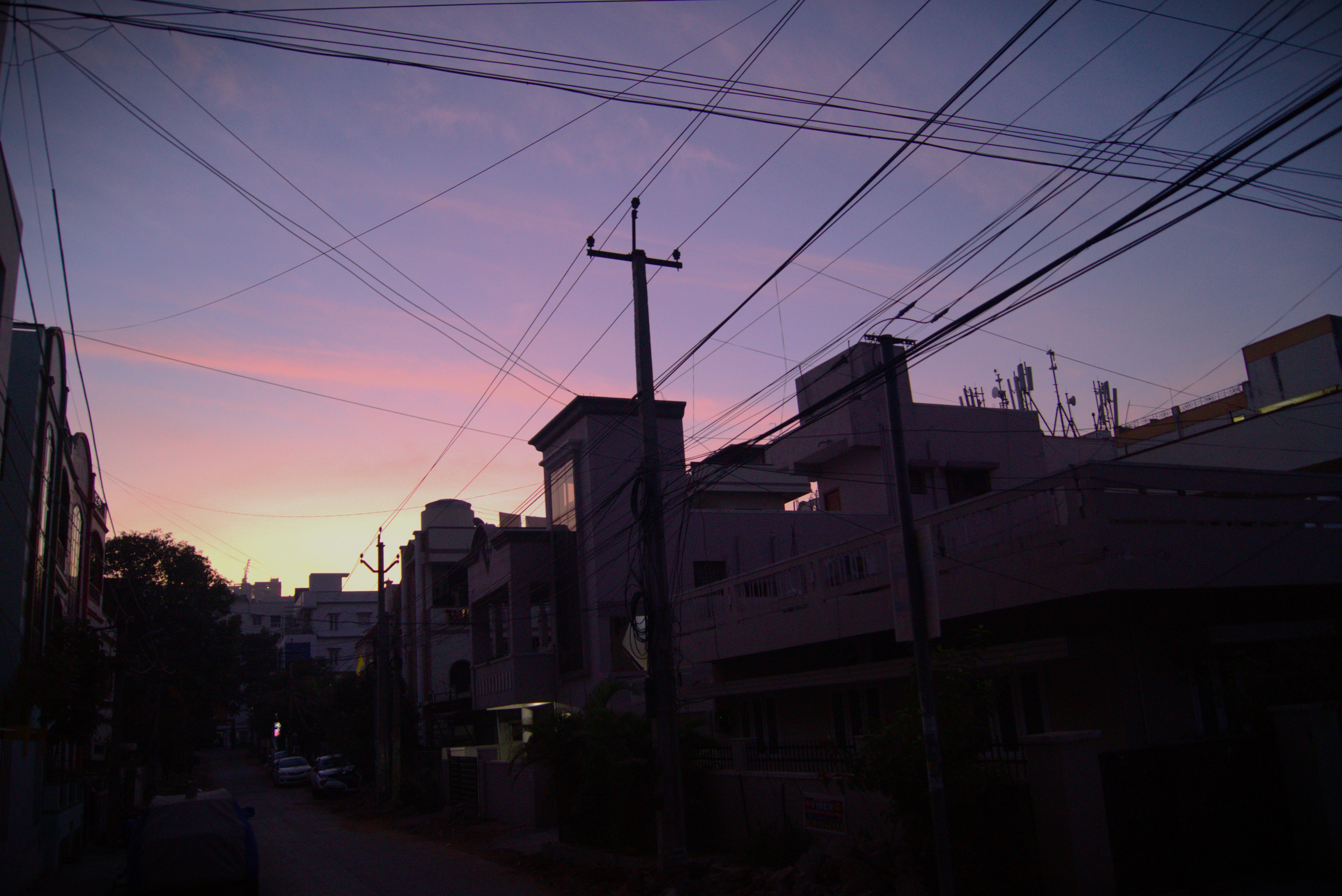 a city street at sunset with power lines overhead
