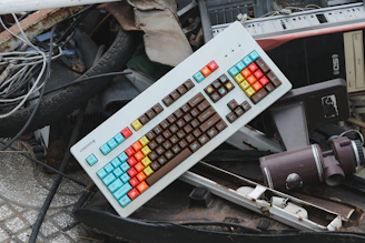 a computer keyboard sitting on top of a pile of junk