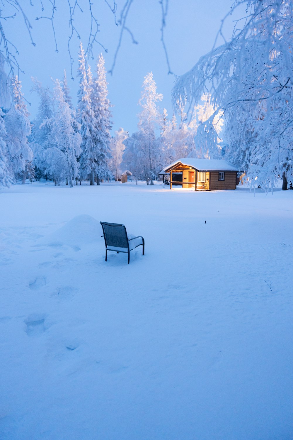 a bench sitting in the middle of a snow covered field