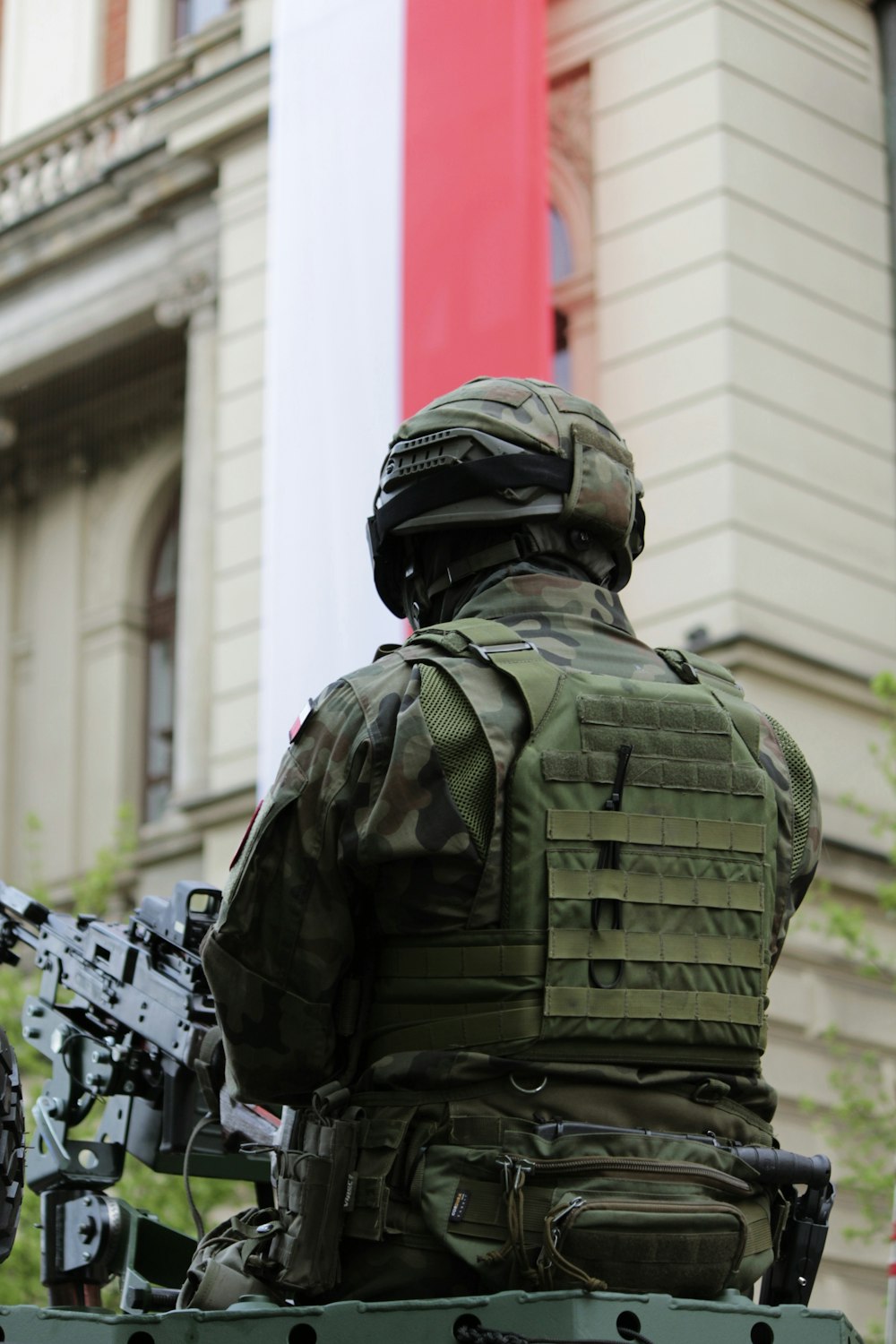 Un soldado sentado en la parte superior de un vehículo verde