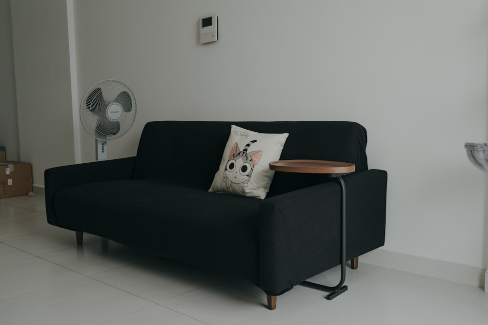 a black couch with a wooden table on top of it