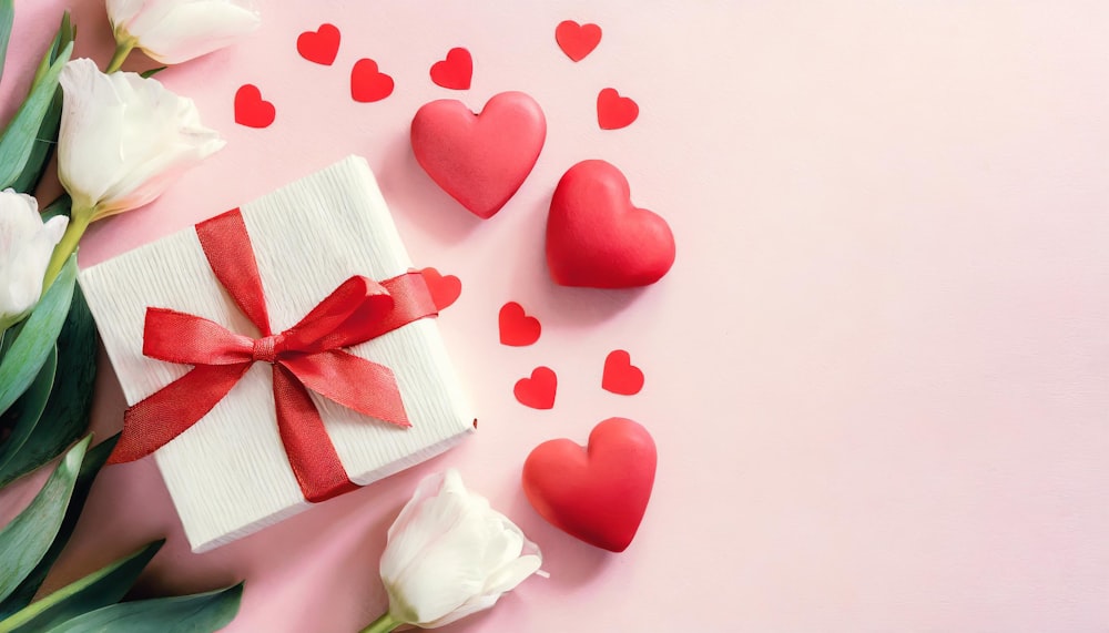 a gift box with a red bow and two hearts on a pink background