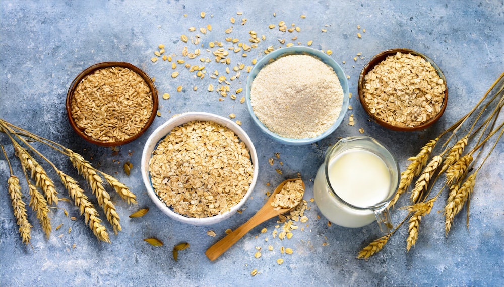 a table topped with bowls of cereal next to a glass of milk