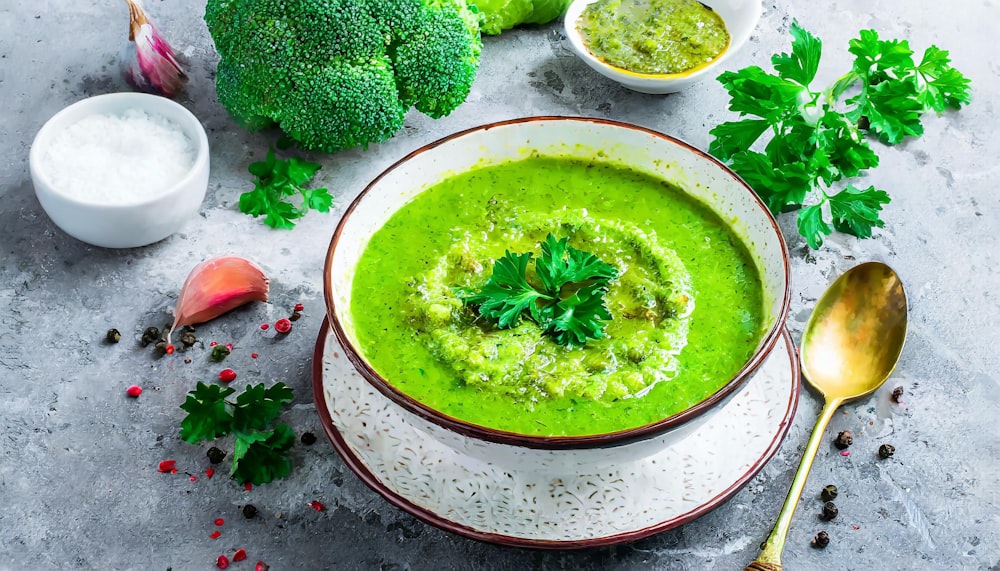 a bowl of broccoli soup on a table