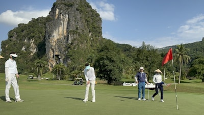 a group of people standing on top of a green field