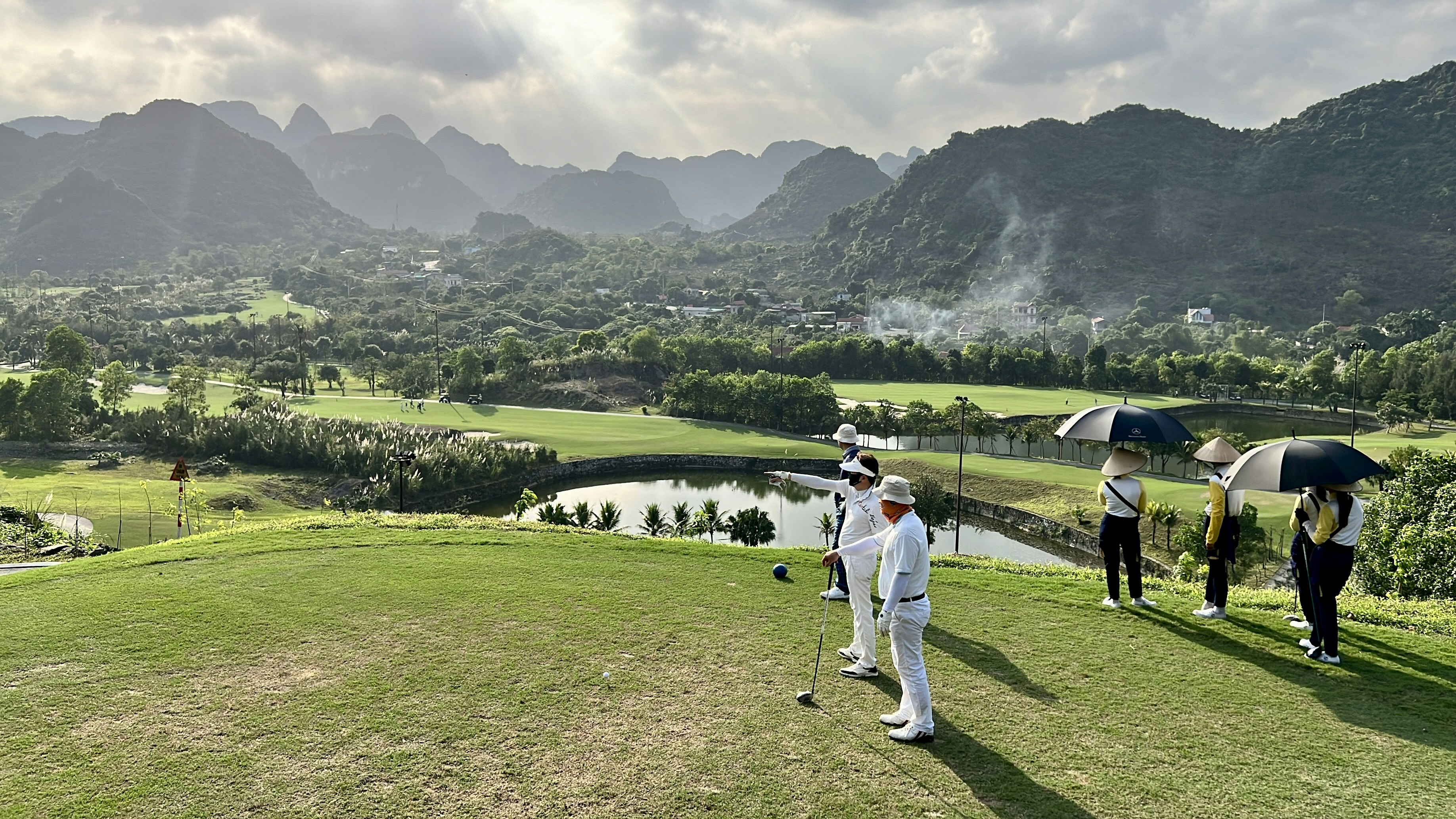 a group of people standing on top of a lush green field