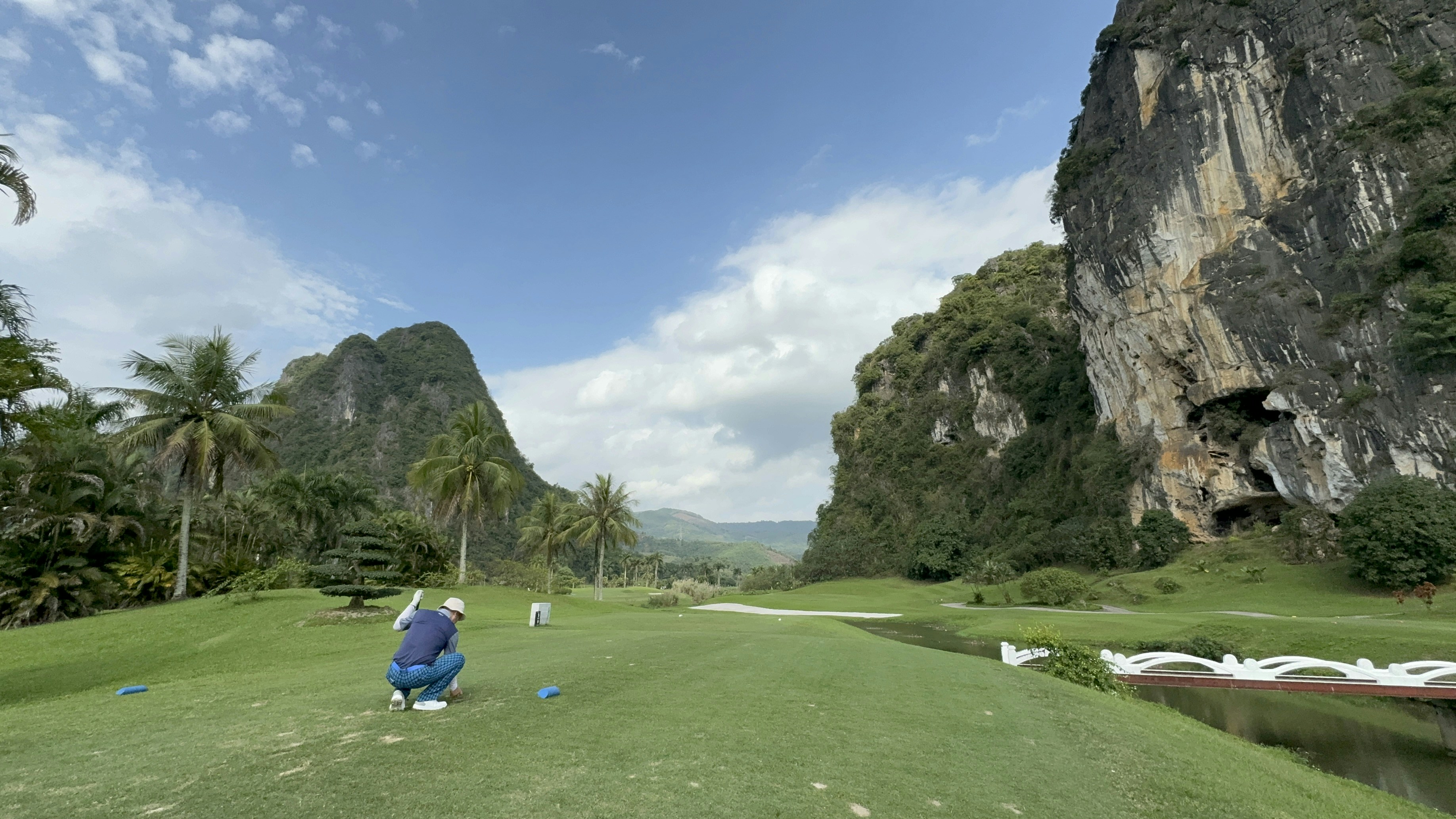 a person on a golf course with mountains in the background