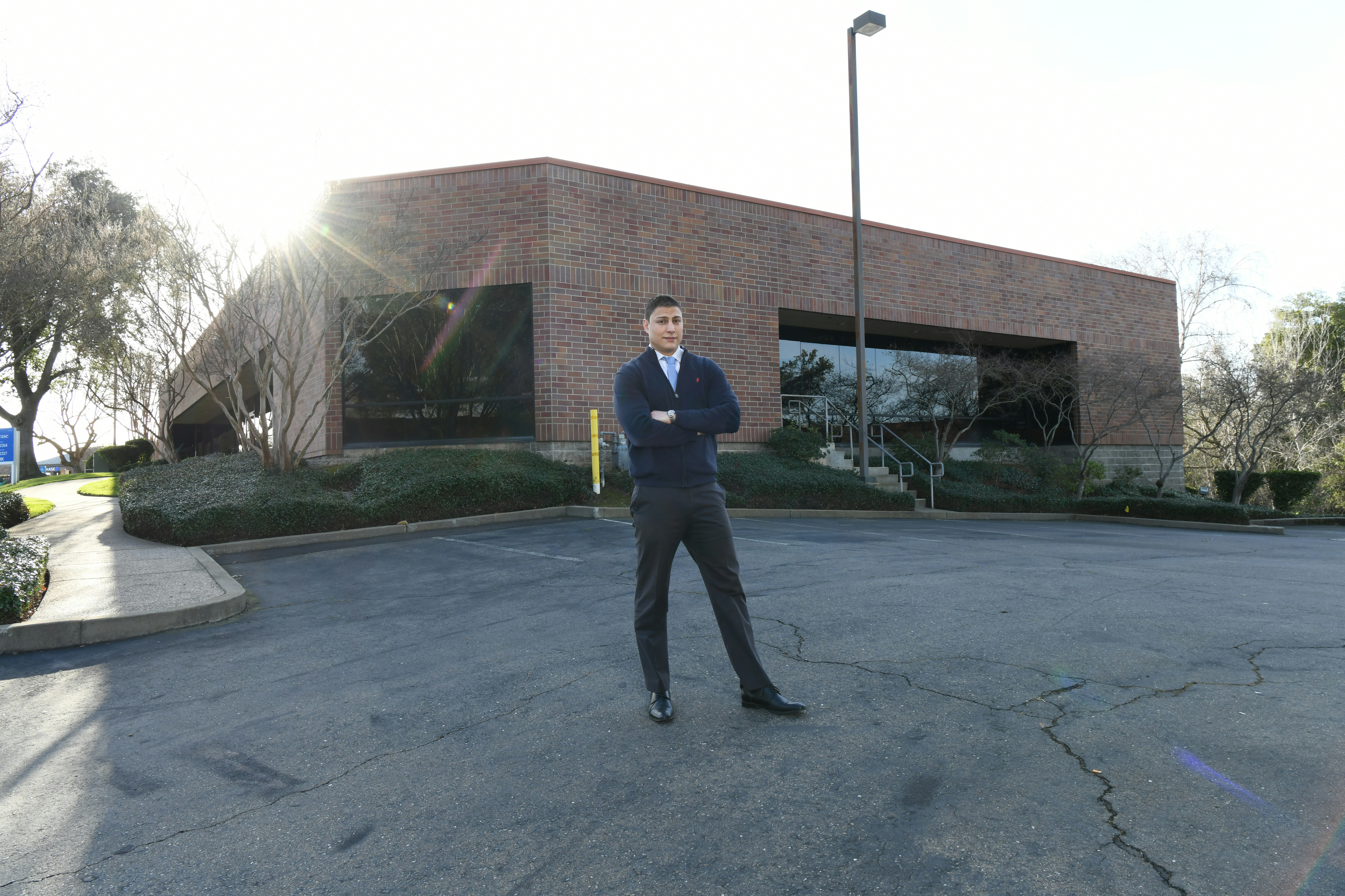 a man in a suit standing in a parking lot