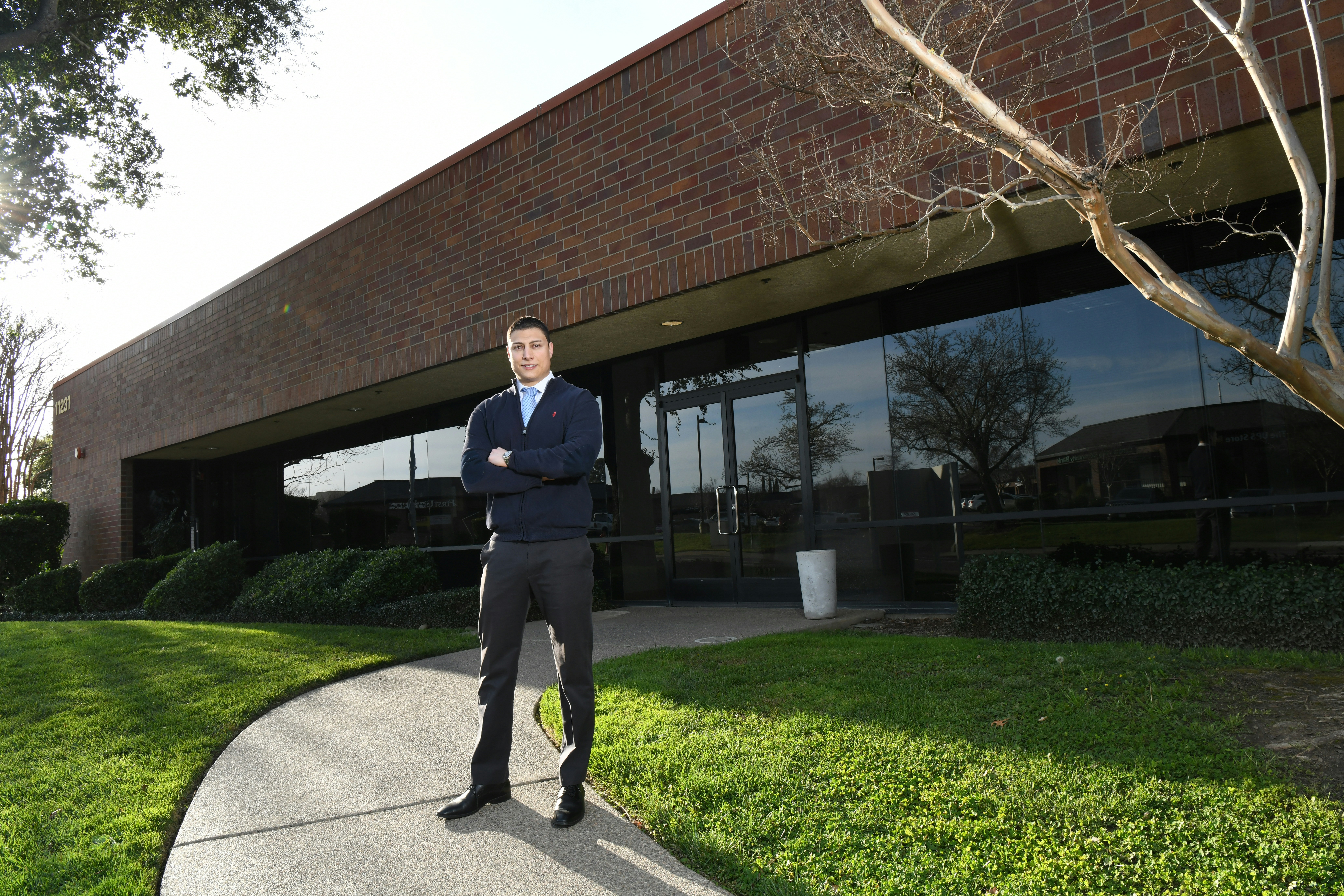 A man in a suit standing in front of a building photo – Free Grey Image ...