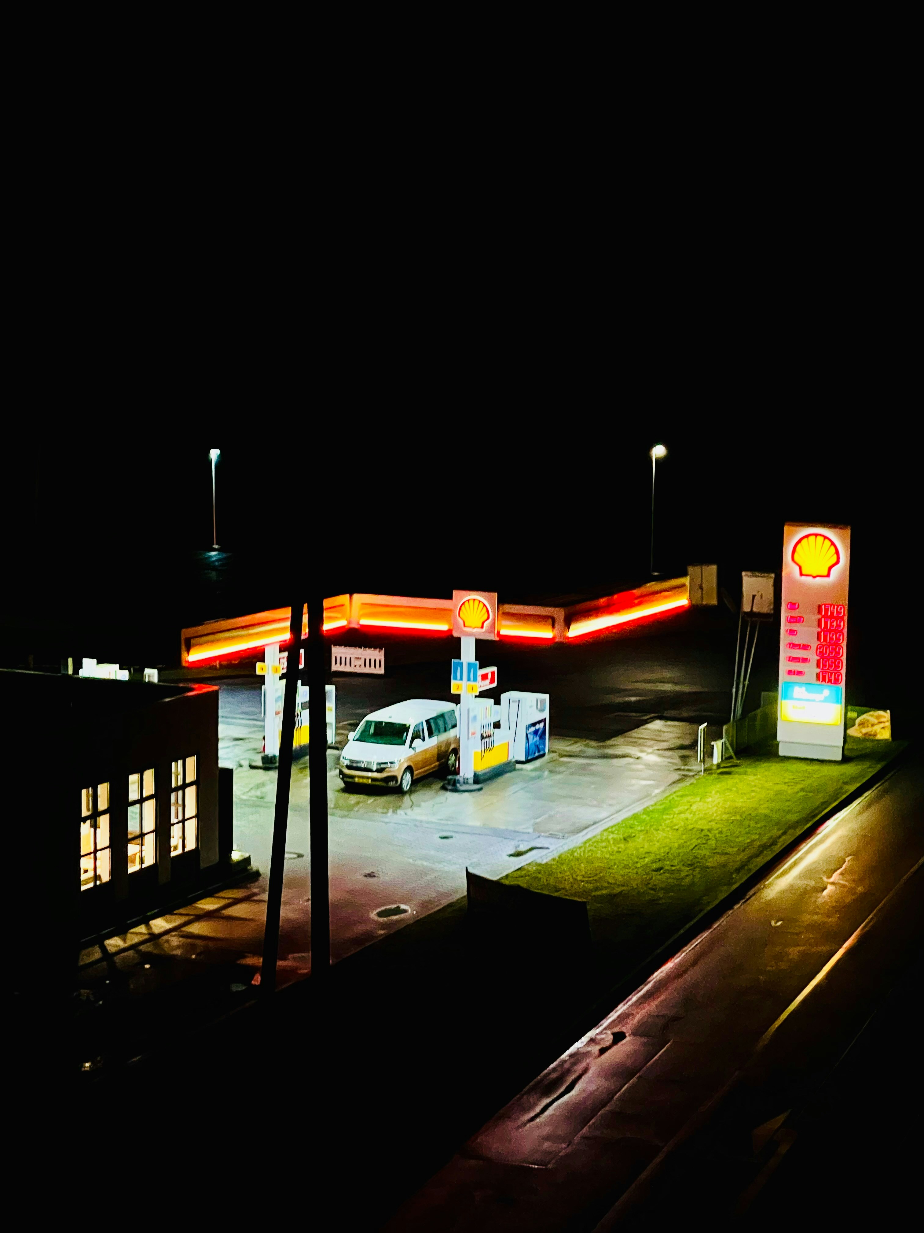 pompa bensin di malam hari dengan mobil diparkir di tempat kejadian