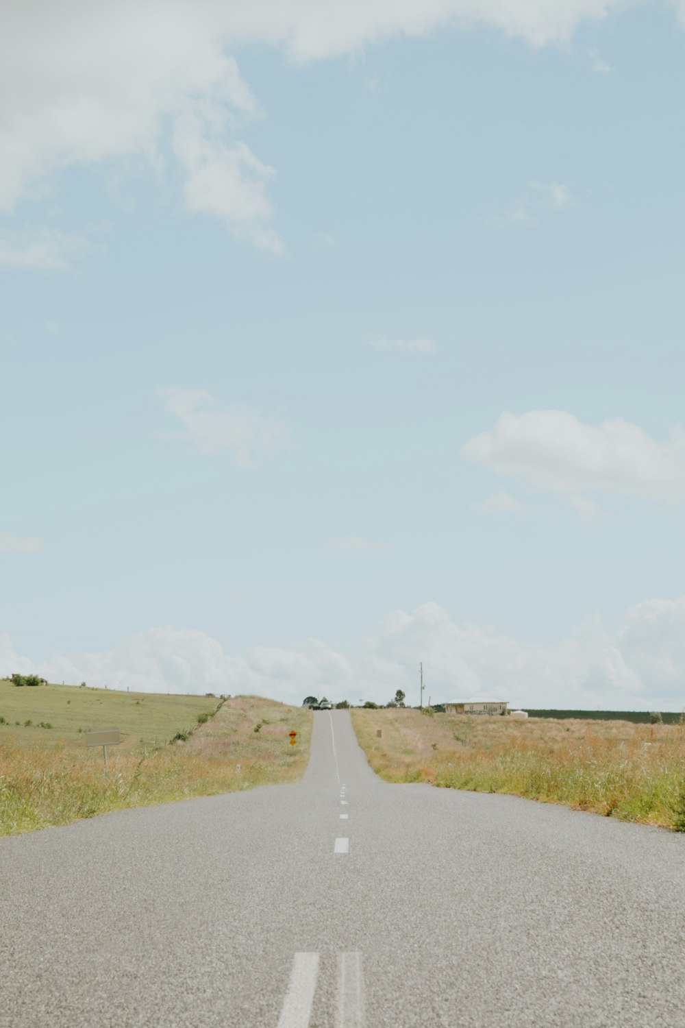 an empty road in the middle of a field