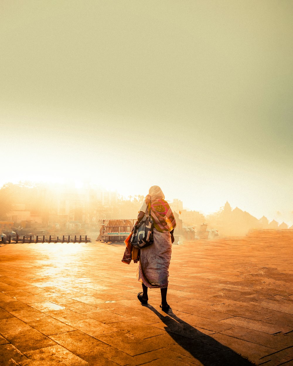 a woman walking down a street with a backpack on her back