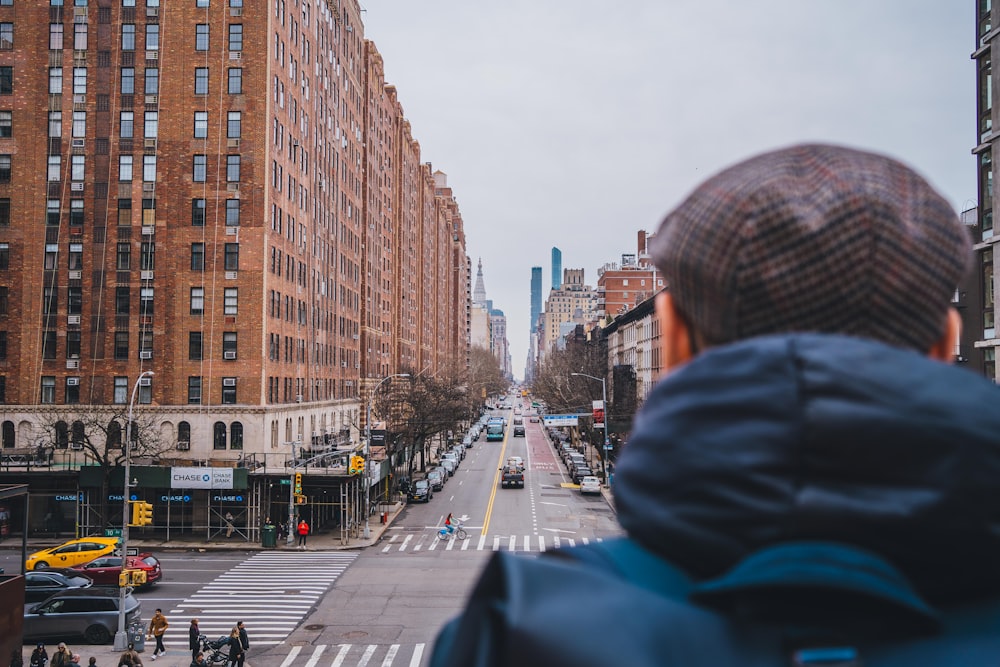 a person standing on a city street looking at buildings