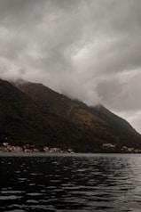 a boat floating on top of a lake under a cloudy sky