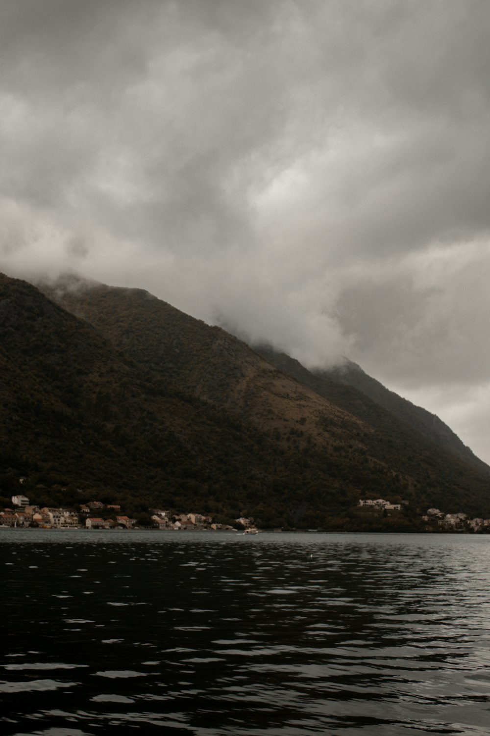 um barco flutuando no topo de um lago sob um céu nublado