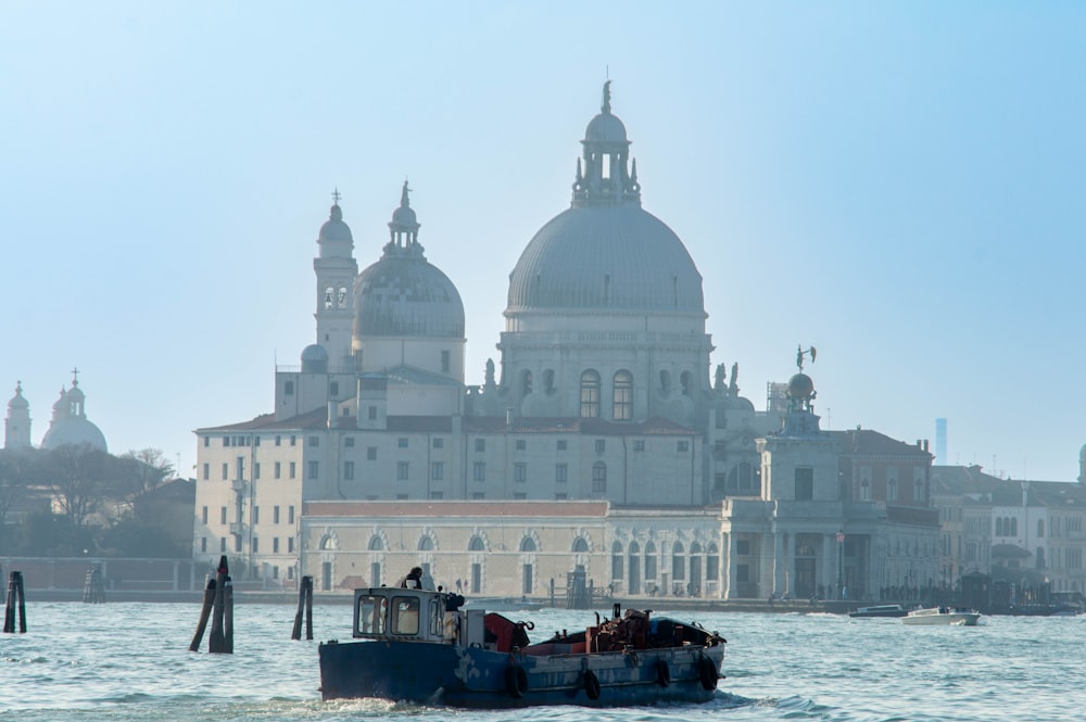 a tug boat in a body of water near a large building