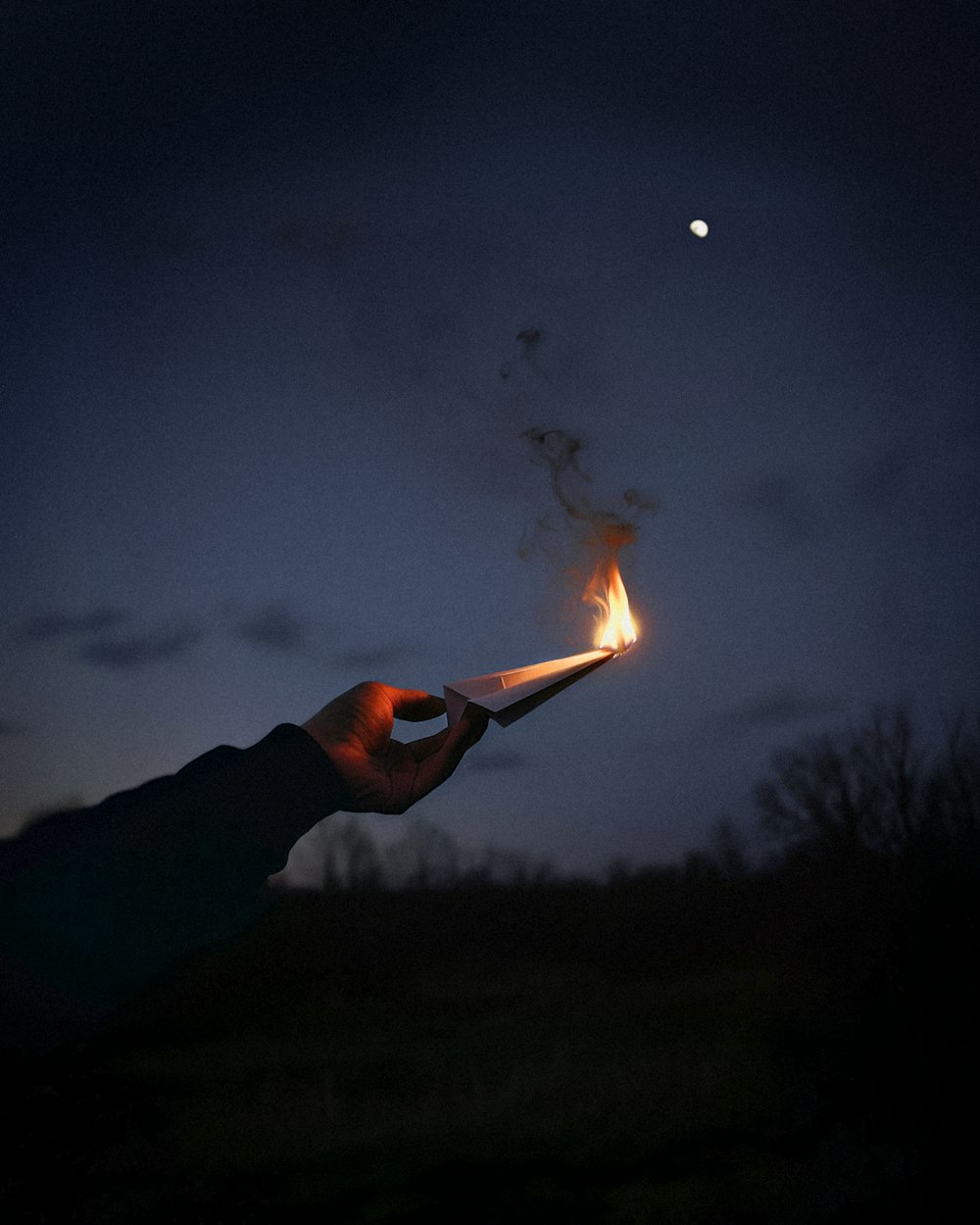 a person holding a lit match in their hand