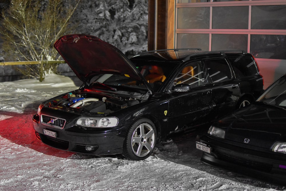 a couple of cars parked next to each other in the snow