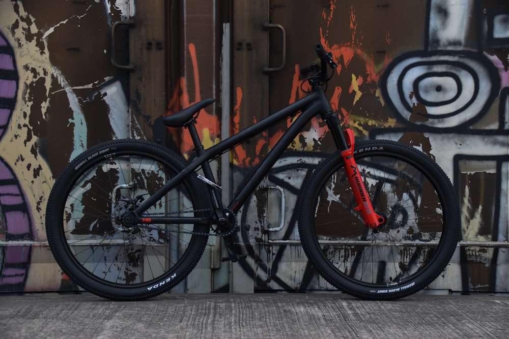 a bike parked in front of a graffiti covered wall