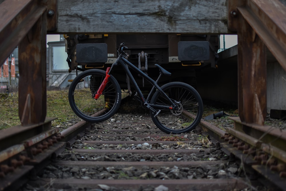 a bike is sitting on the tracks under a bridge