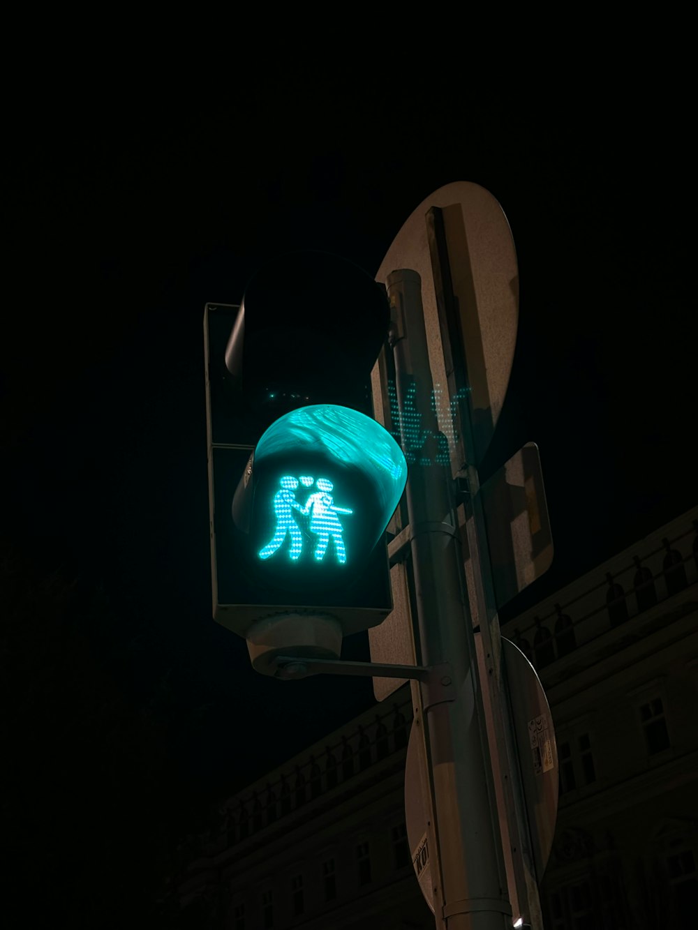 a green traffic light with a picture of two people on it