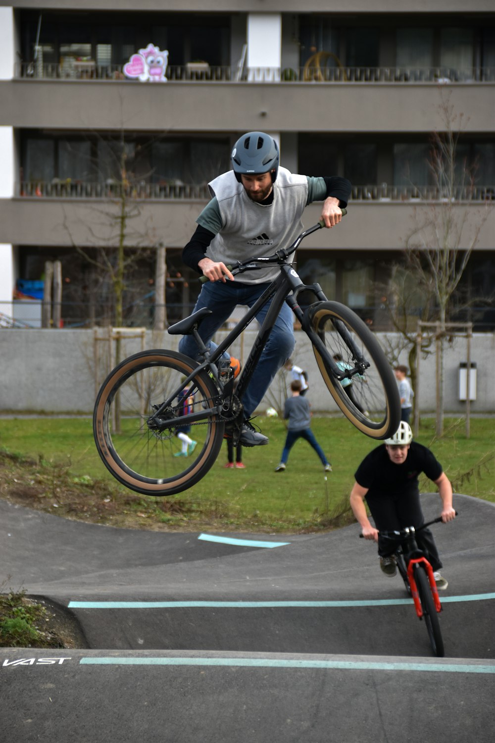 a man on a bike jumping over another man on a skateboard