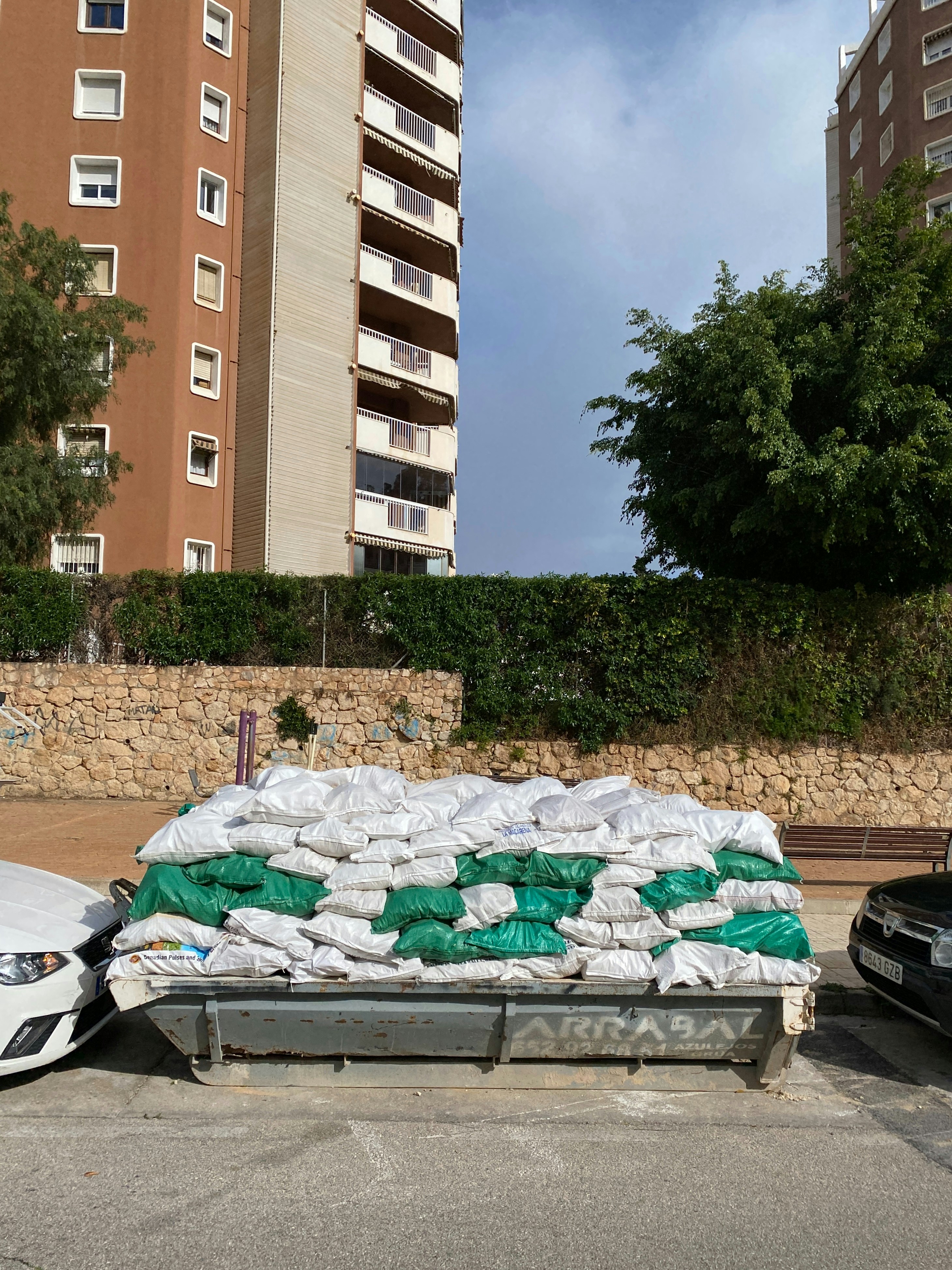 a pile of sand sitting next to a parking lot
