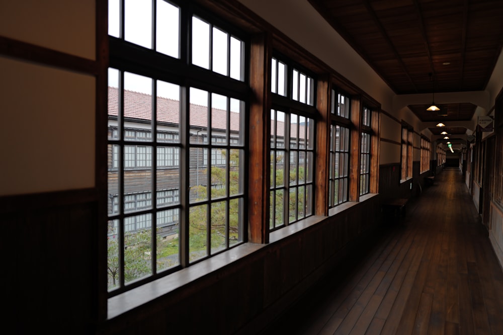 a long hallway with lots of windows and wooden floors
