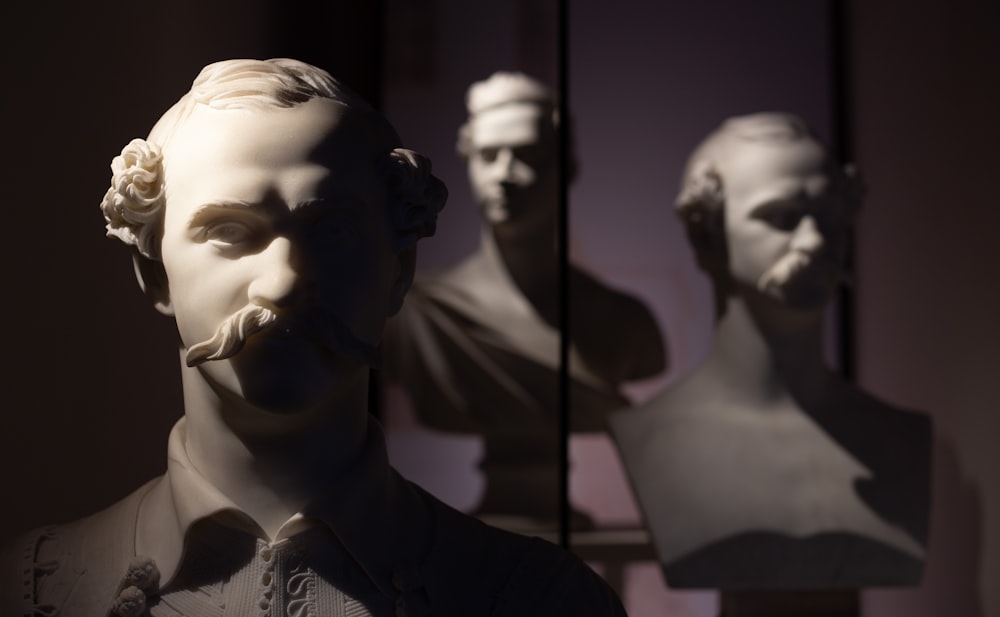 una estatua de un hombre con barba frente a un espejo