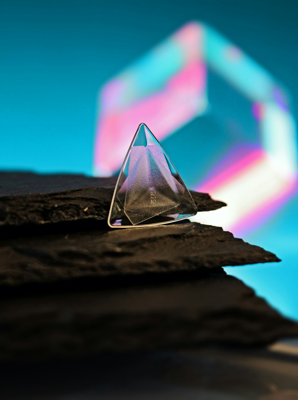 a triangle shaped object sitting on top of a piece of wood