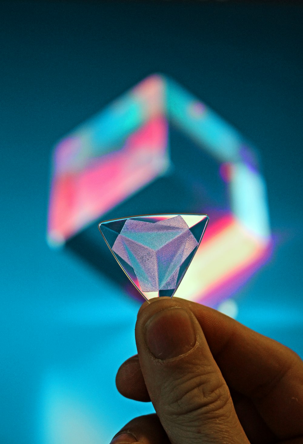 a person holding a small diamond in their hand
