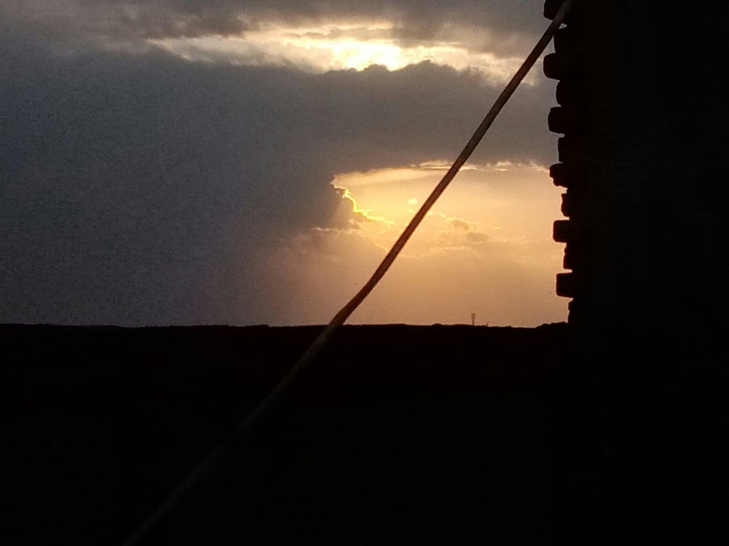 the sun is setting behind the clouds in the sky