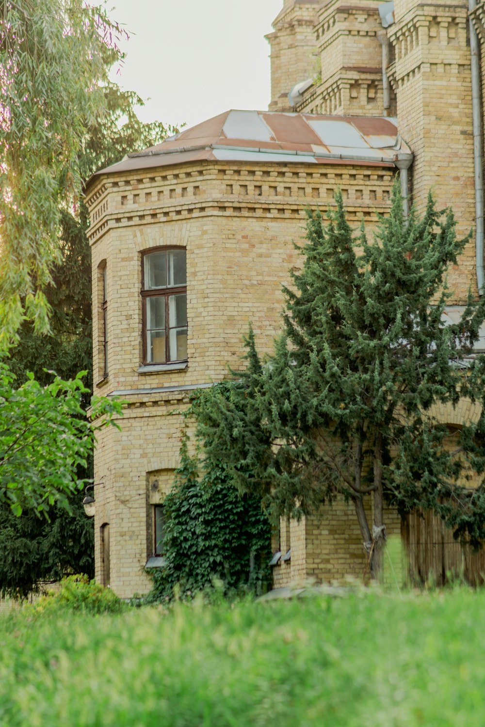 an old brick building with a tree in front of it