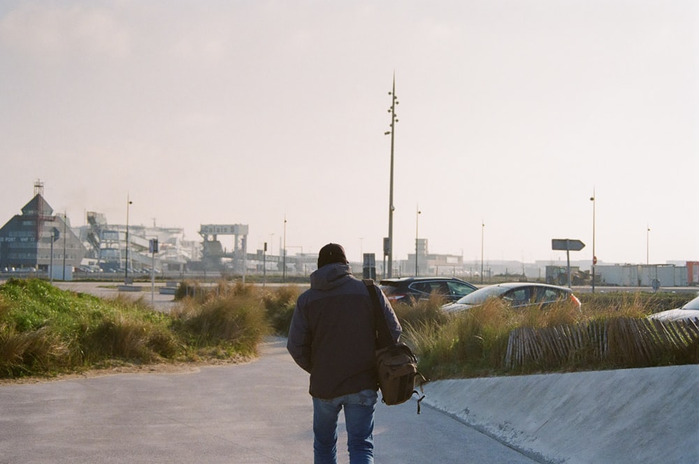 a man walking down a street with a skateboard