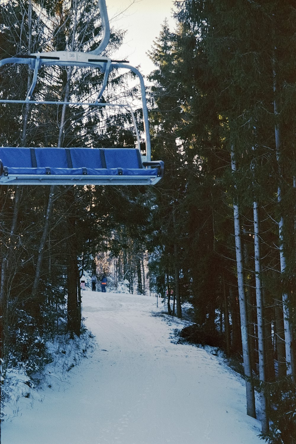 a blue ski lift going up a snowy hill