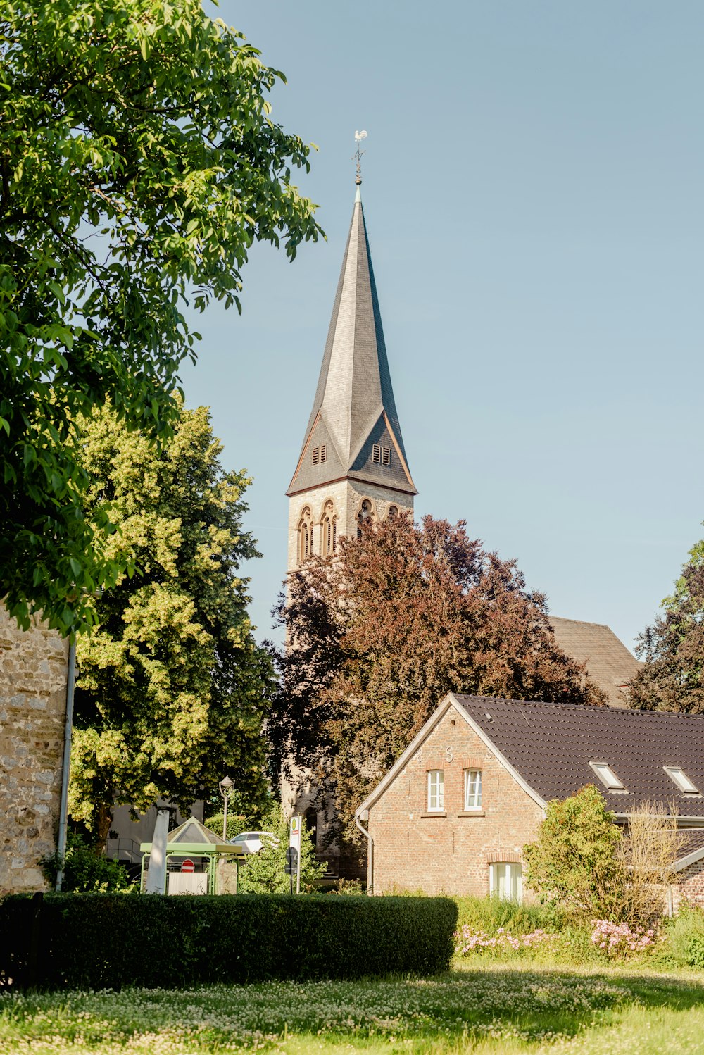 a church with a steeple surrounded by trees