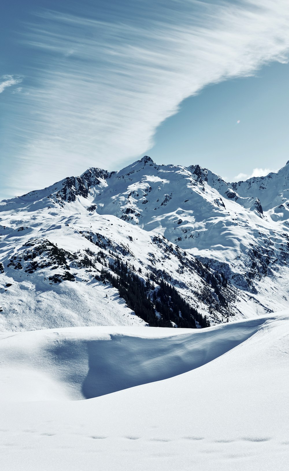 a mountain covered in snow under a blue sky