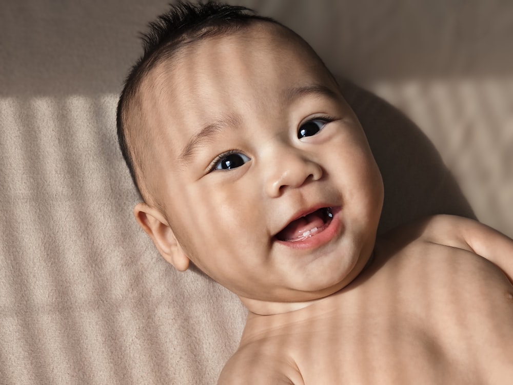 a close up of a baby laying on a bed