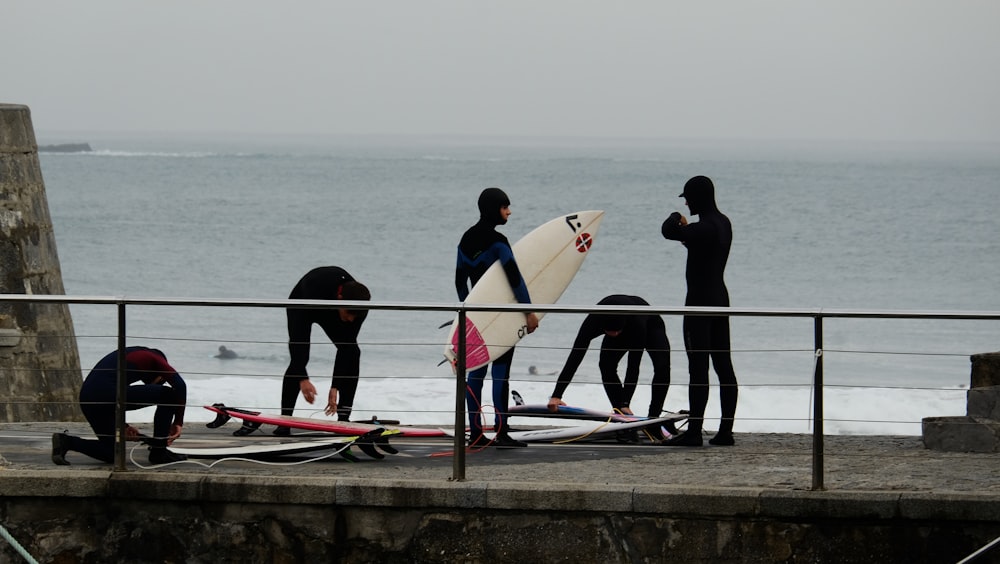 un gruppo di persone con tavole da surf su un molo