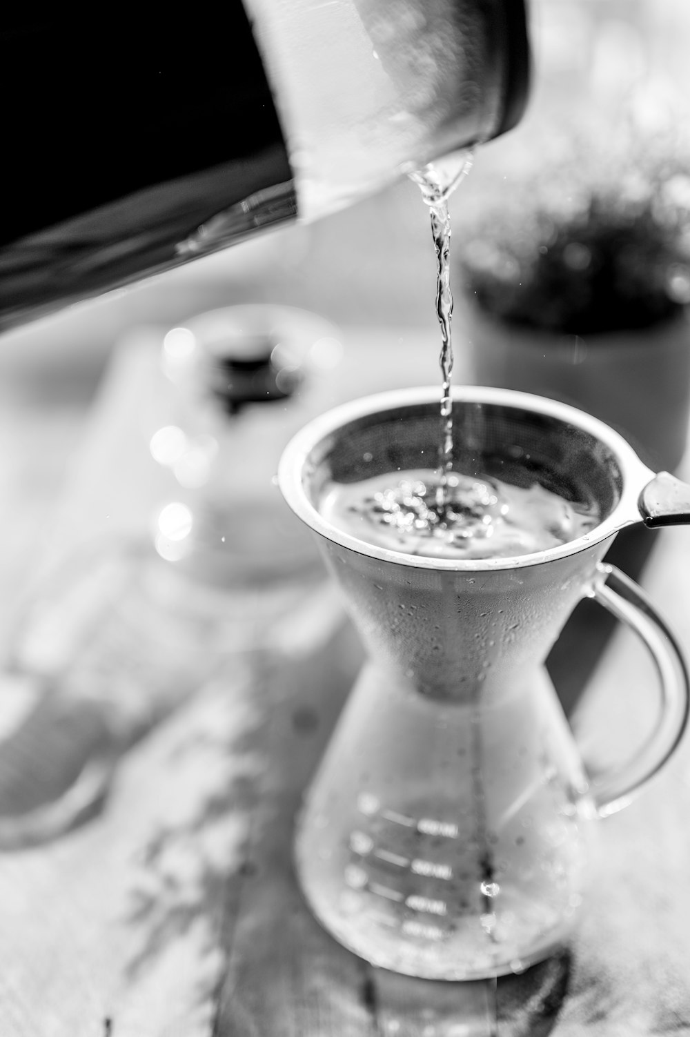 a pitcher pouring water into a cup on a table