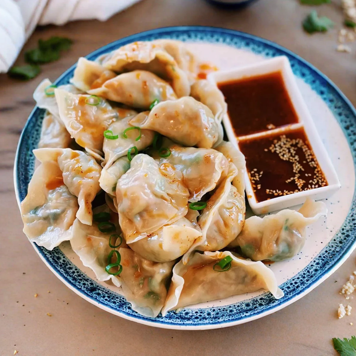 A plate of steamed momos with dipping sauce