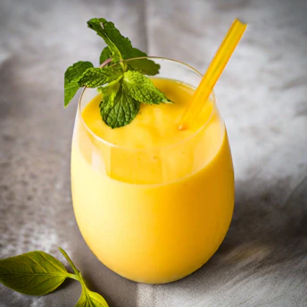 a glass of orange juice with a straw