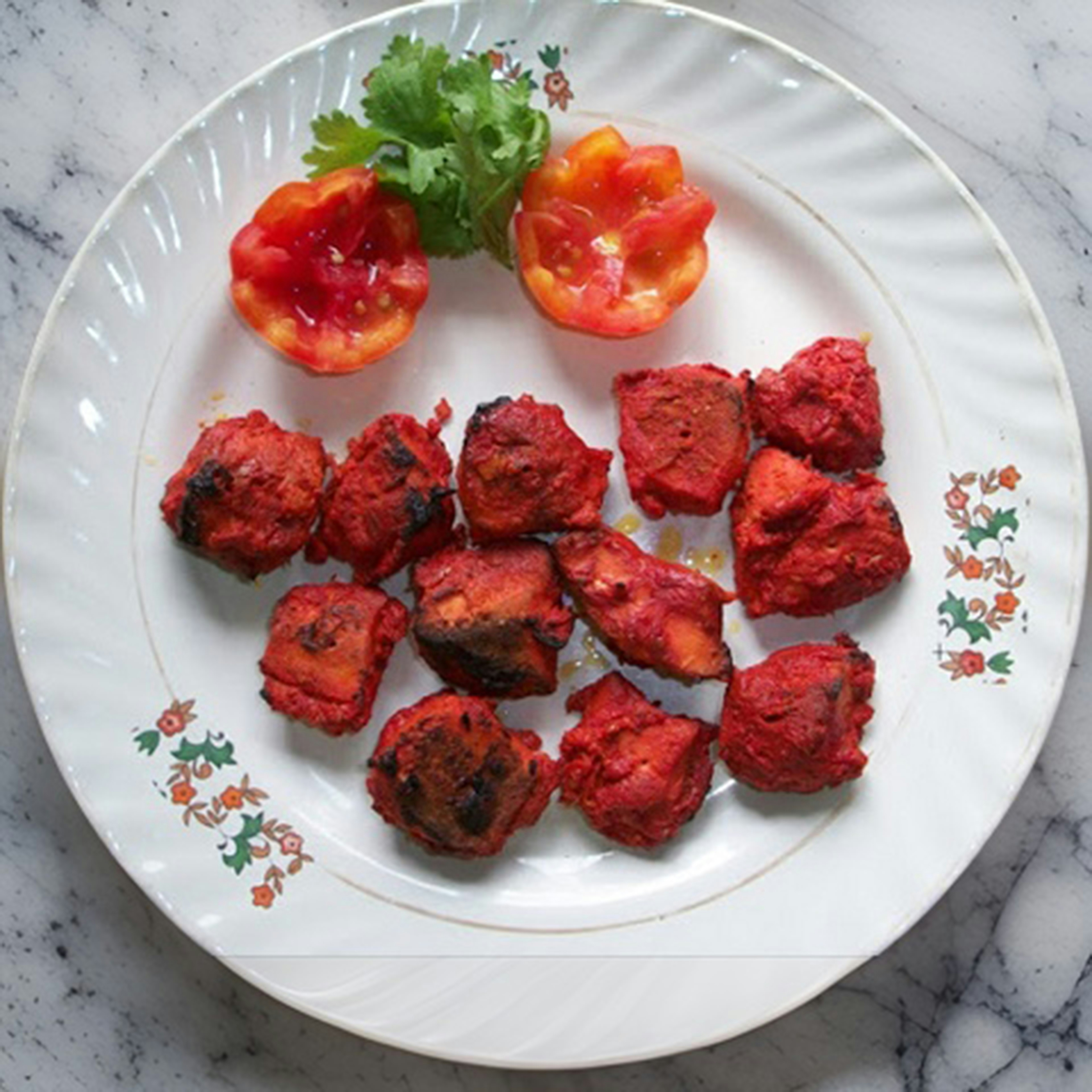 a white plate topped with meatballs and tomatoes