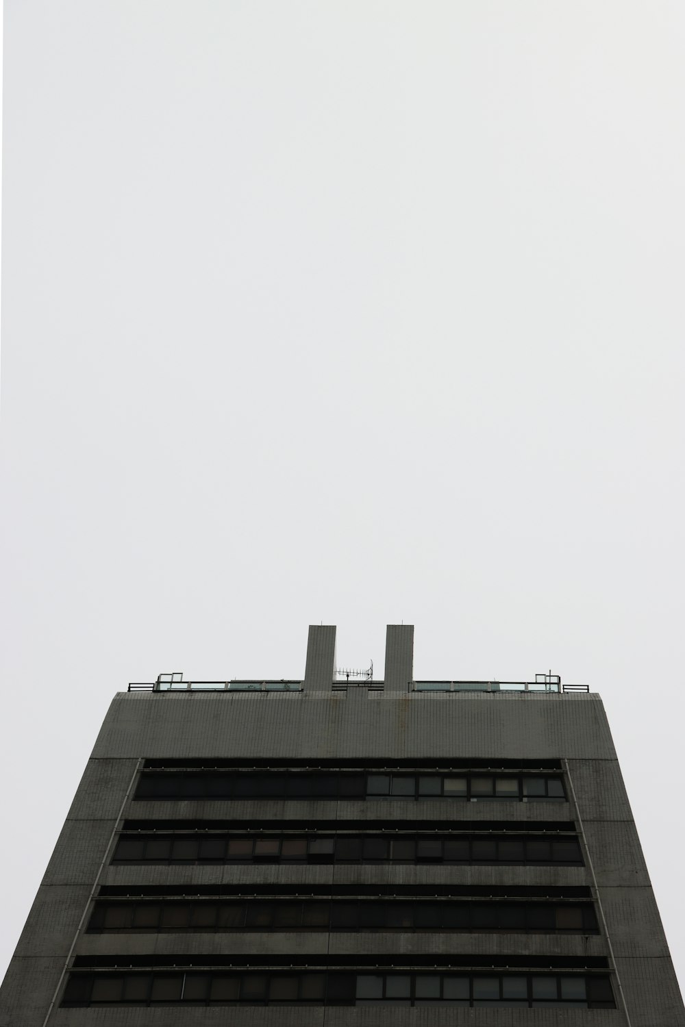 an airplane flying in the sky over a tall building