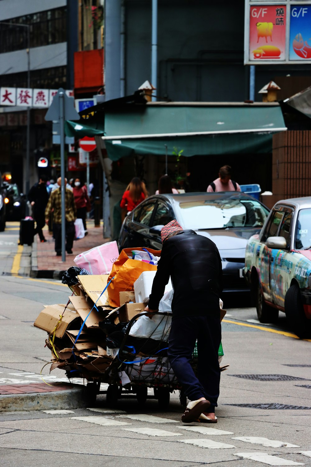 a man pushing a cart full of boxes down a street