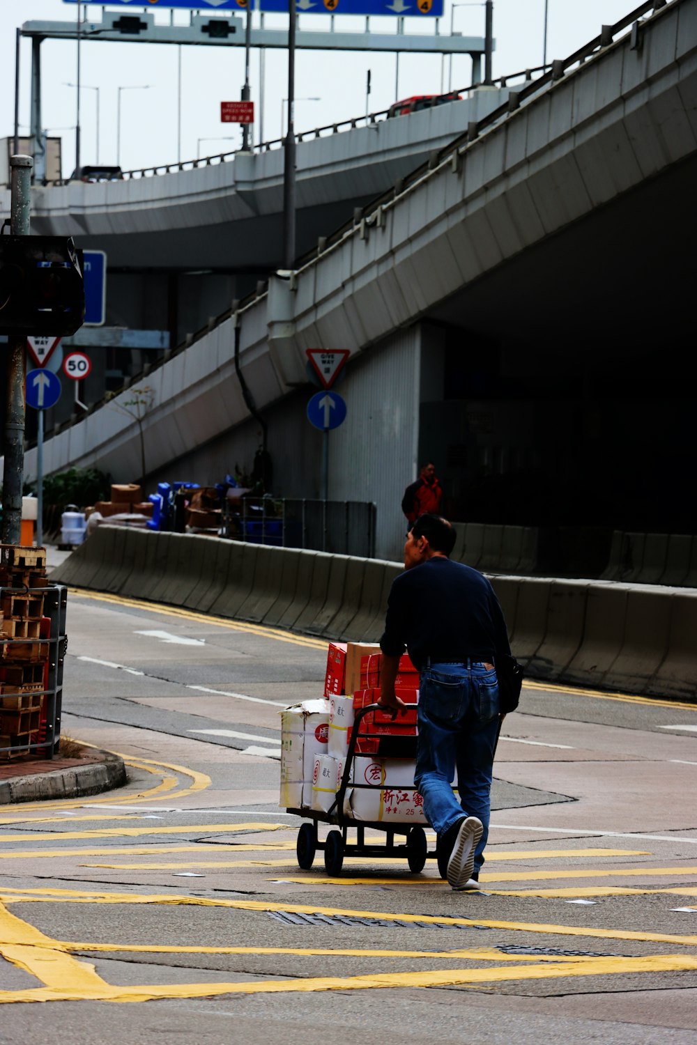 a man pushing a cart with a bunch of boxes on it