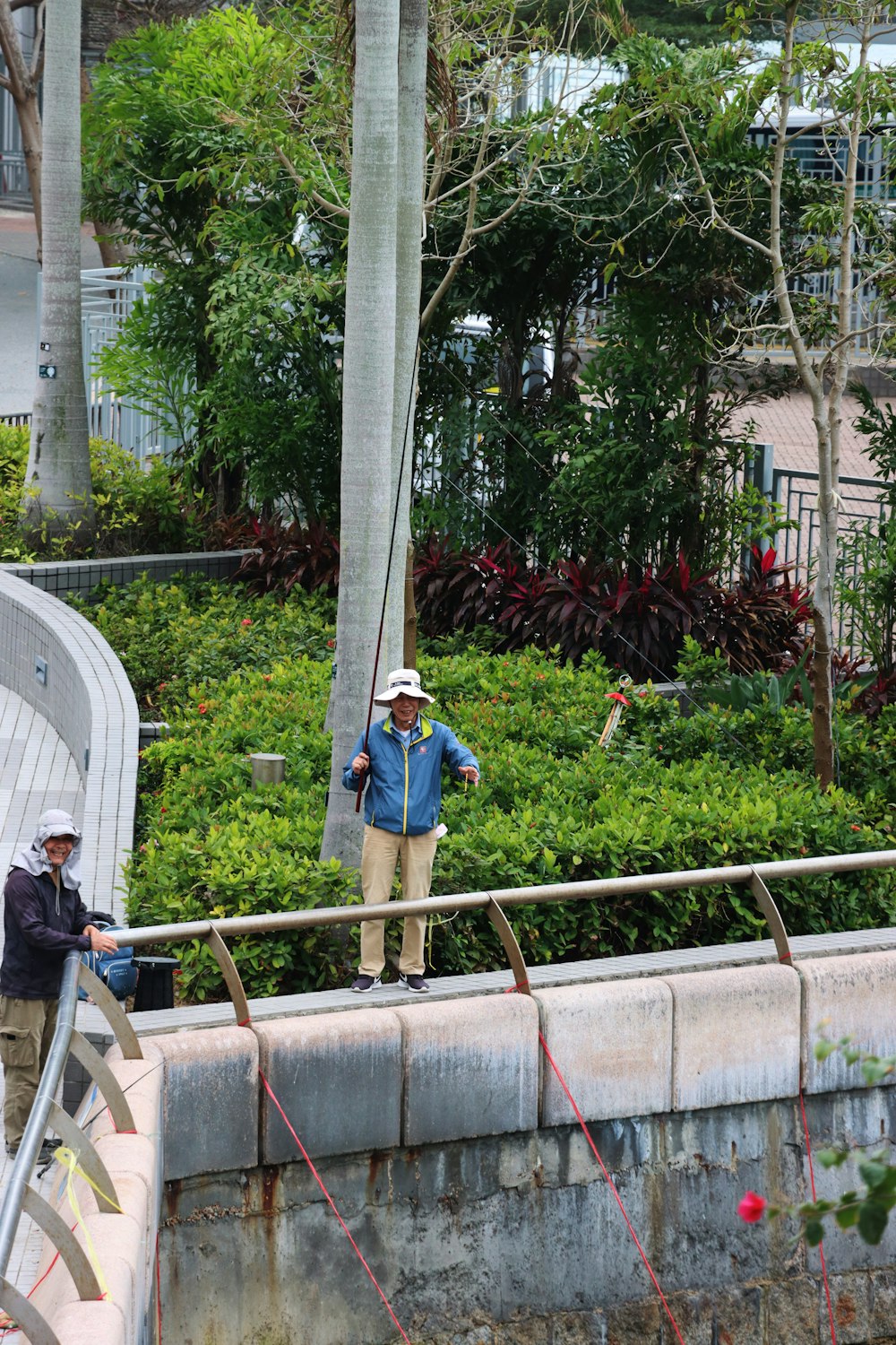 a man standing on a bridge next to a lush green park