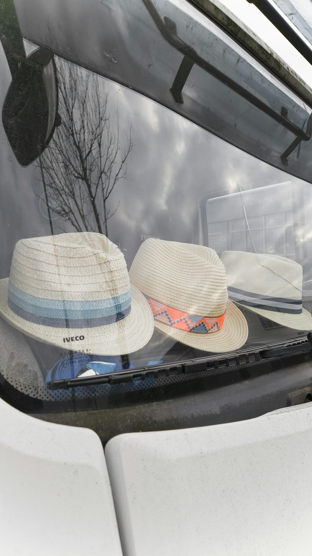 three hats sitting on top of a window sill