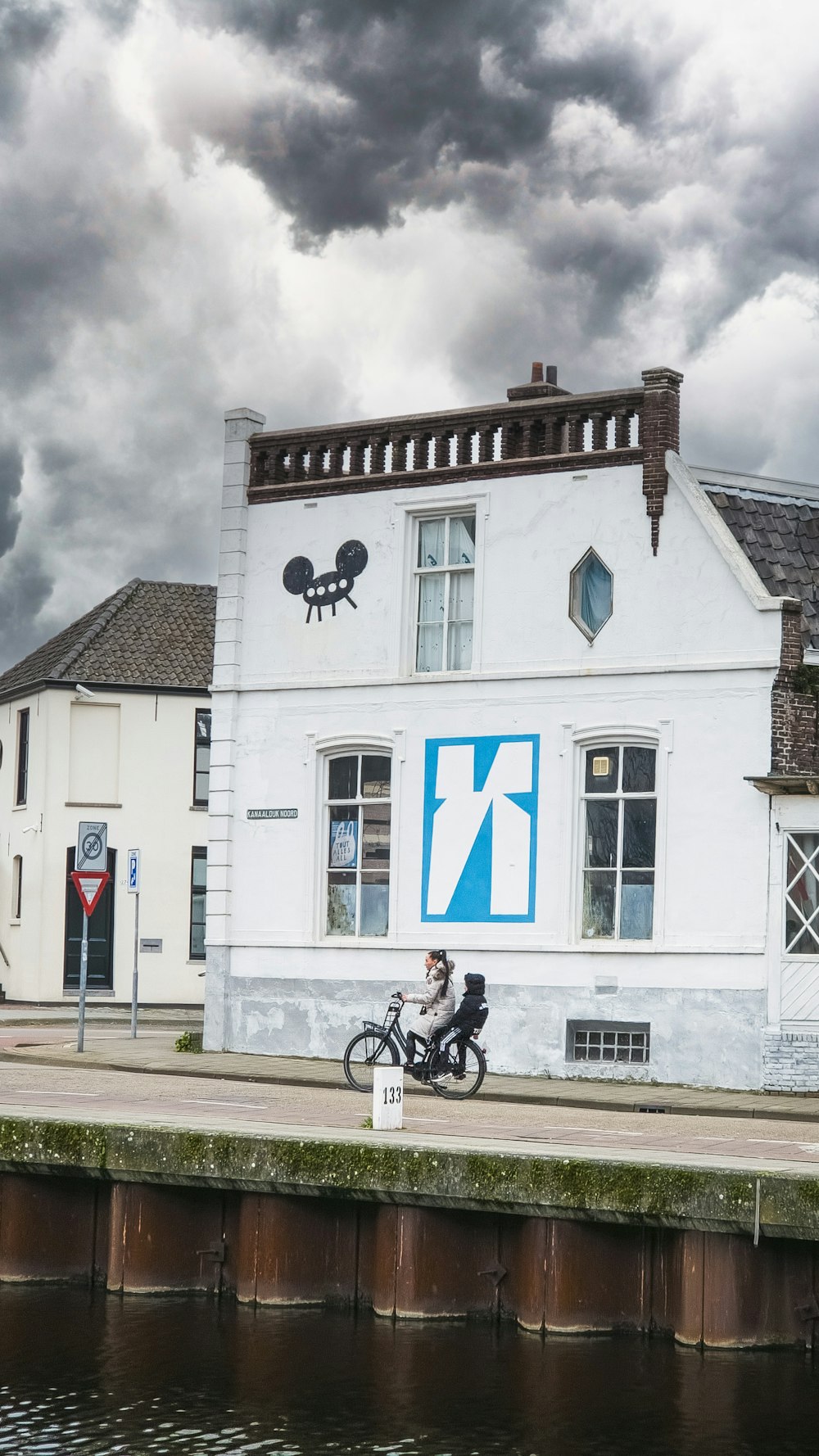 a man riding a bike next to a white building