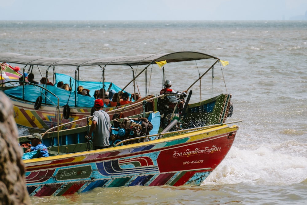 a group of people riding on the back of a colorful boat